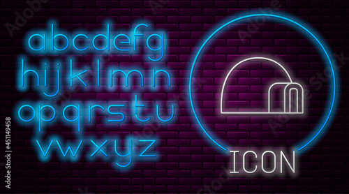 Glowing neon line Igloo ice house icon isolated on brick wall background. Snow home, Eskimo dome-shaped hut winter shelter, made of blocks. Neon light alphabet. Vector