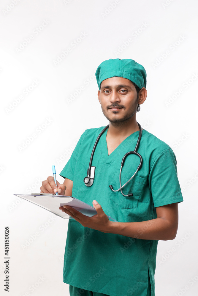Young indian male doctor in uniform with stethoscope taking notes in notepad over white background. Young indian male doctor in uniform with stethoscope taking notes in notepad over white background.