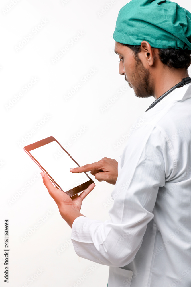 Young indian male doctor using smartphone at clinic. Young indian male doctor using smartphone at clinic.