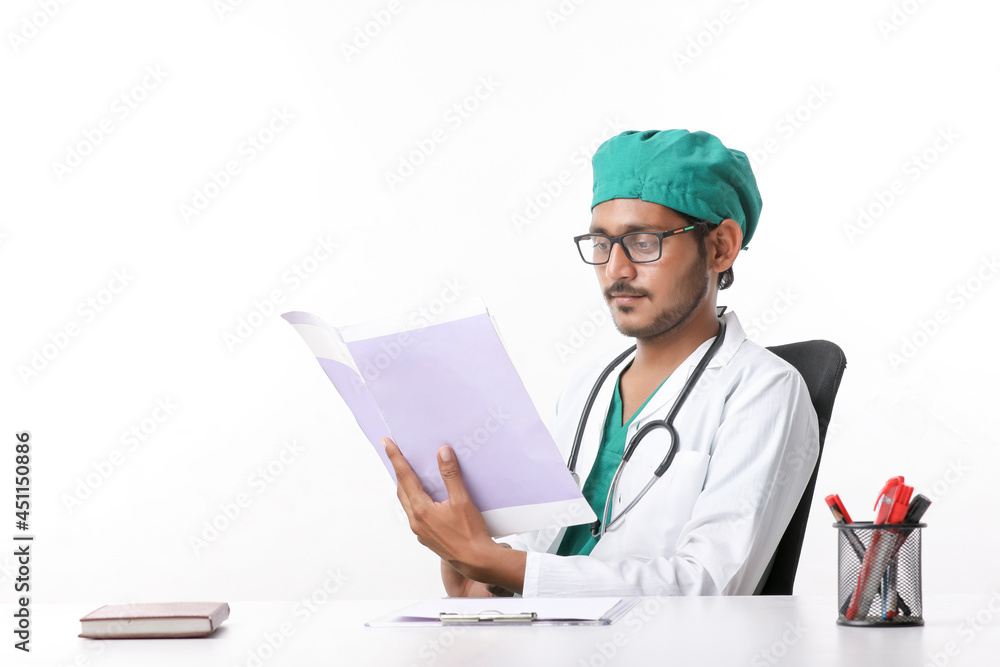 Young indian doctor checking file at clinic Young indian doctor checking file at clinic