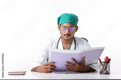 Young indian doctor checking file at clinic