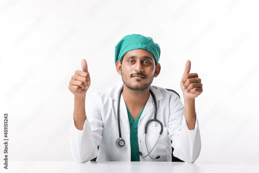 Doctor in a white coat with a stethoscope and showing thumbs up over white background. Doctor in a white coat with a stethoscope and showing thumbs up over white background.