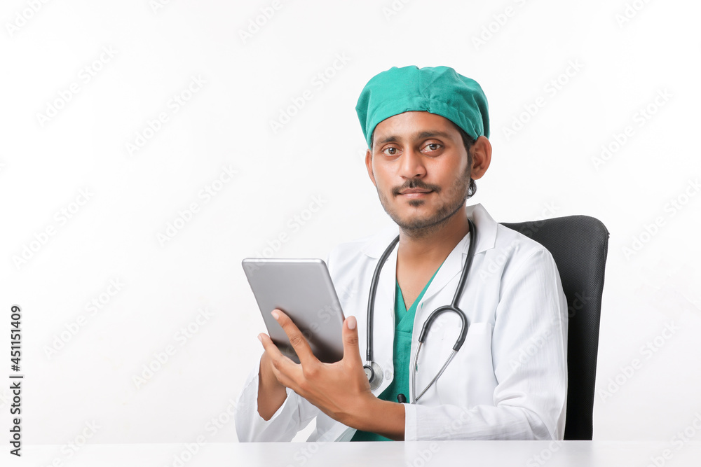 Young indian male doctor using smartphone at clinic. Young indian male doctor using smartphone at clinic.