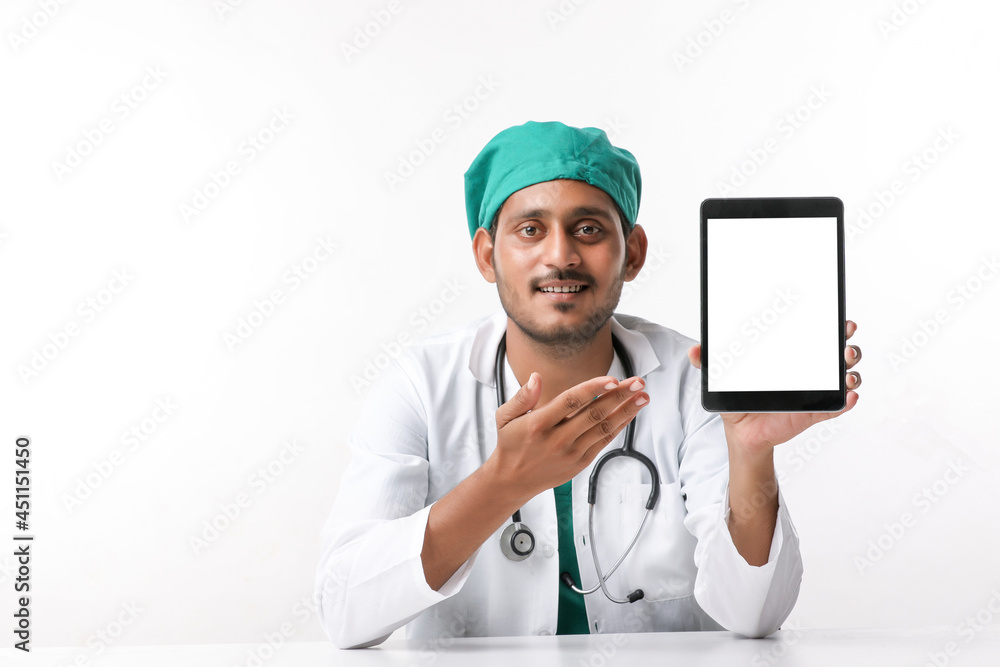 Young indian doctor showing tablet screen at clinic. Young indian doctor showing tablet screen at clinic.
