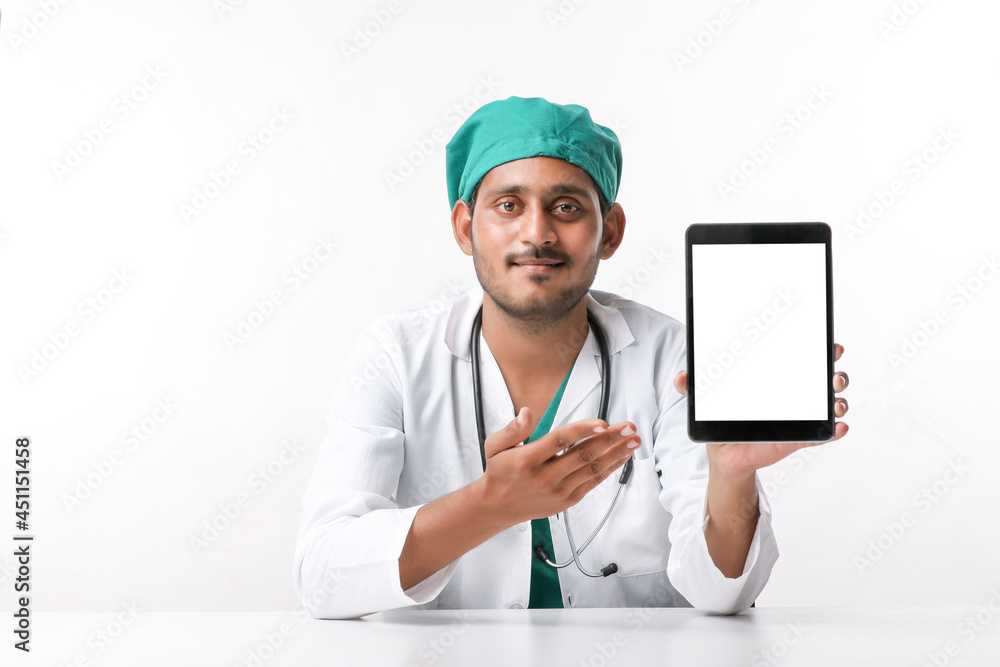 Young indian doctor showing tablet screen at clinic.