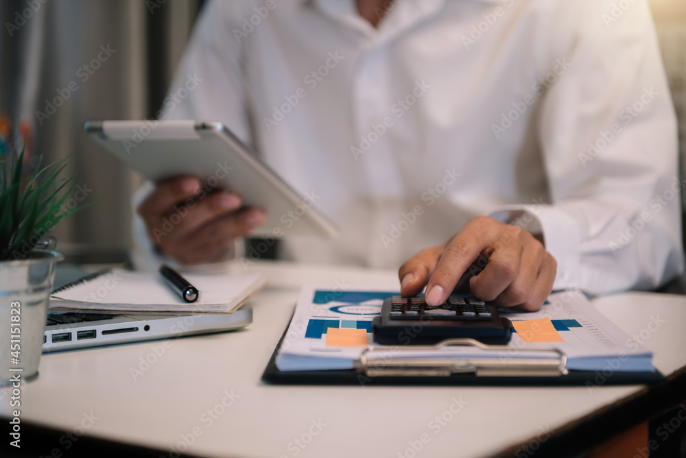 Fototapeta premium Accountant working on tablet with business document, graph diagram and calculator on office table in office.