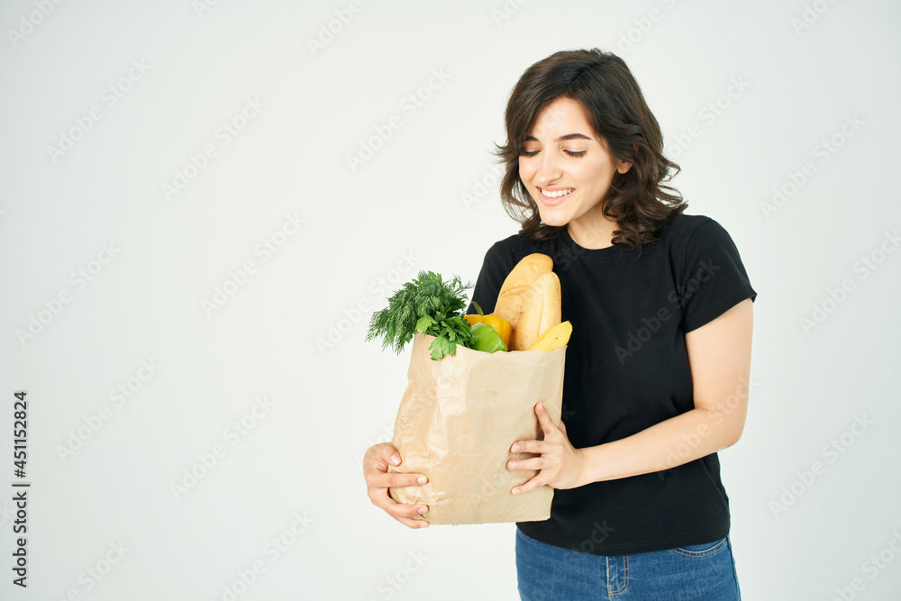 brunette with a package of groceries vegetables healthy food delivery from supermarket brunette with a package of groceries vegetables healthy food delivery from supermarket