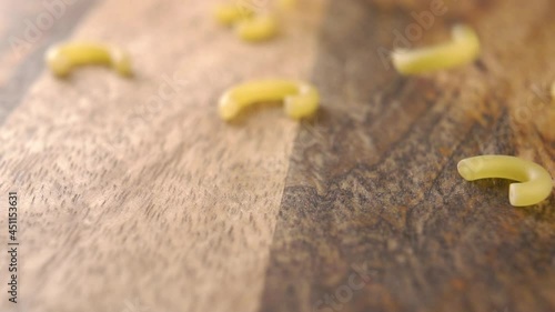 Raw traditional gobbetti pasta fall on a wooden board. Old european Italian cuisine concept. Slow motion. Macro shot photo