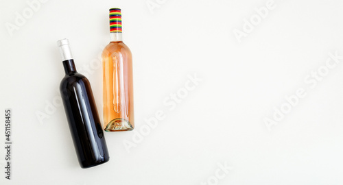 Rose wine bottle and red wine bottle . Minimalistic wine composition top view on white background copy space. Two bottles of Wine brand mockup. Long web banner Flat lay.