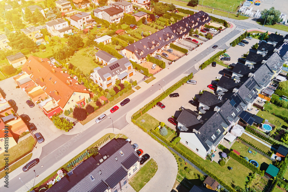 Modern residential district in Europe town, aerial view. Residential neigborhood in sunset, bird eye view. City streets with luxury house buildings and parked car