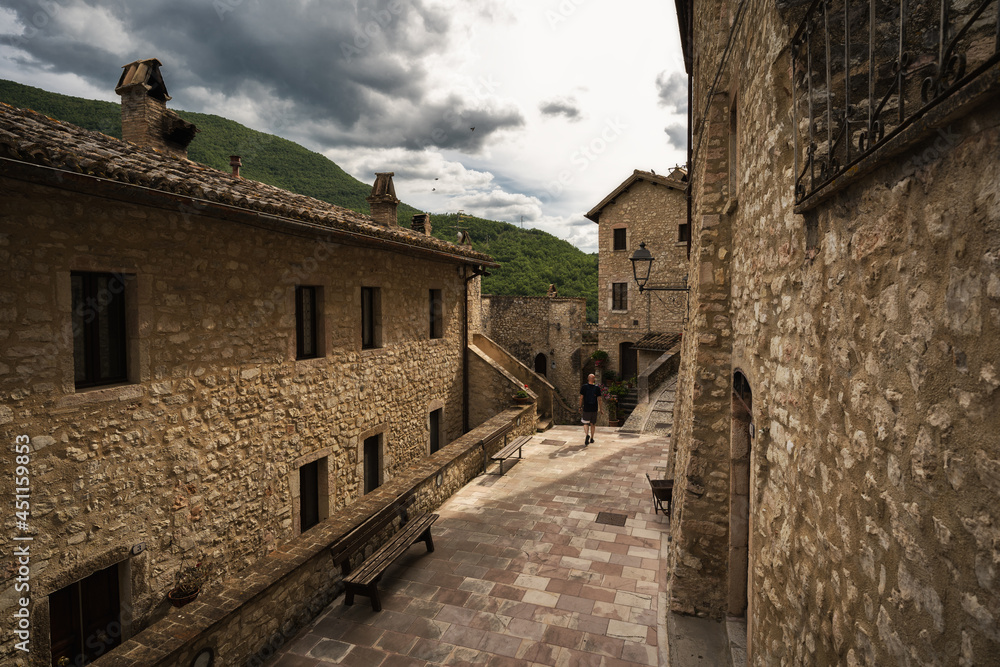a young man walking into the little street of Vallo di nera, Umbria