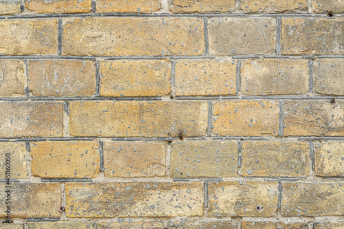 Close-up of an old brick wall of the late 19th century made of light brown bricks.