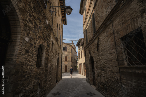 A young man is walking into a beautiful old town