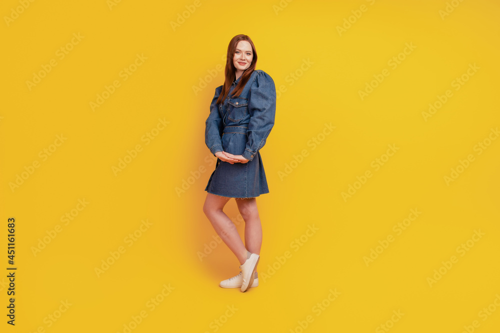Portrait of coquette flirty tempting lady posing wear denim short dress footwear on yellow background Portrait of coquette flirty tempting lady posing wear denim short dress footwear on yellow background