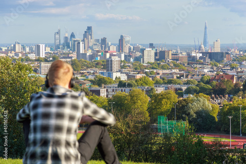 View of London city skyline from Parliament Hill in Hampstead Heath through a tourist  photo