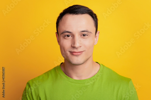 Portrait of handsome charming smiling man look camera on yellow background
