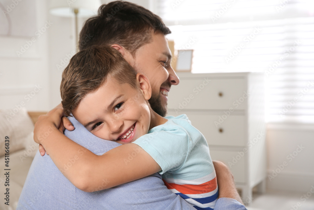 Cute little boy hugging his father at home. Adoption concept