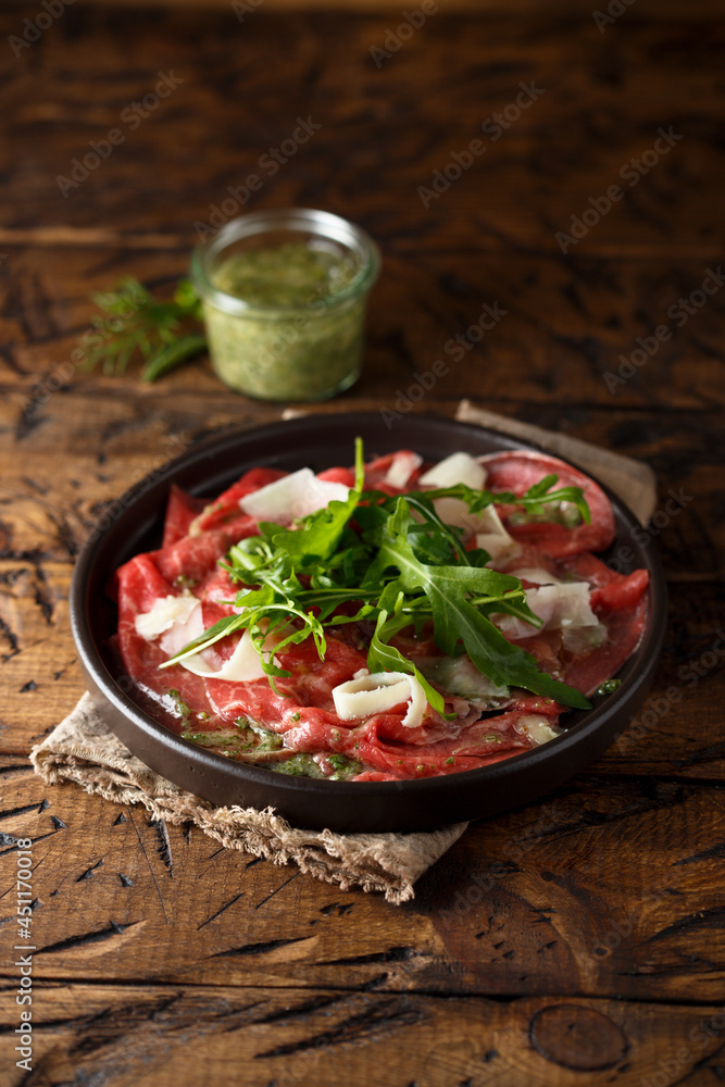 Traditional homemade beef carpaccio with arugula Traditional homemade beef carpaccio with arugula