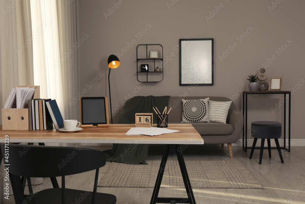 Comfortable workplace with tablet on wooden table in modern office. Interior design Comfortable workplace with tablet on wooden table in modern office. Interior design