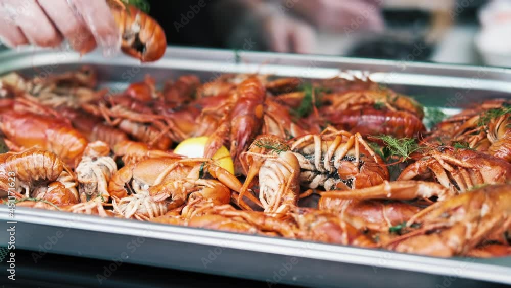 Cook filling plateau with cooked crayfish. Food festival Cook filling plateau with cooked crayfish. Food festival