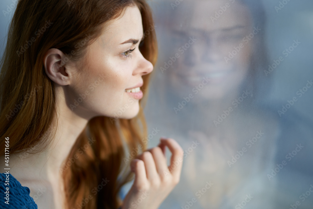 pretty woman sitting near the window with a blue plaid smile at home pretty woman sitting near the window with a blue plaid smile at home