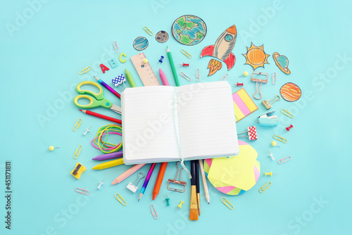 Back to school concept. Top view image of open empty notebook and student stationery over pastel blue background