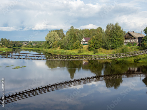 Suspension bridge over the Olonka river in the village of Verkhovye in the Olonets district of the Republic of Karelia, northwestern Russia photo