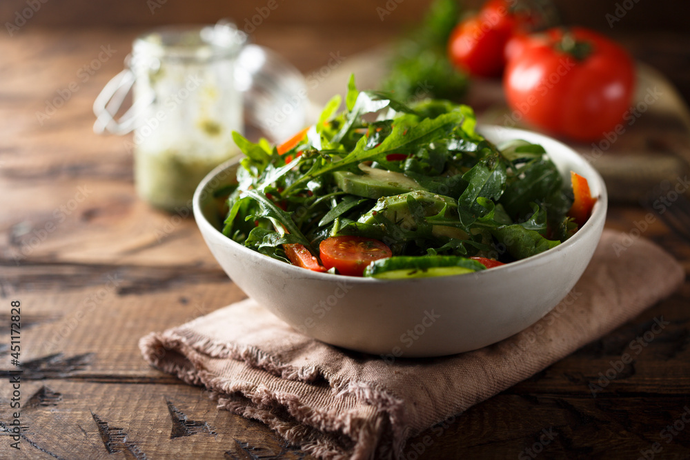 Healthy arugula salad with tomato and cucumber Healthy arugula salad with tomato and cucumber