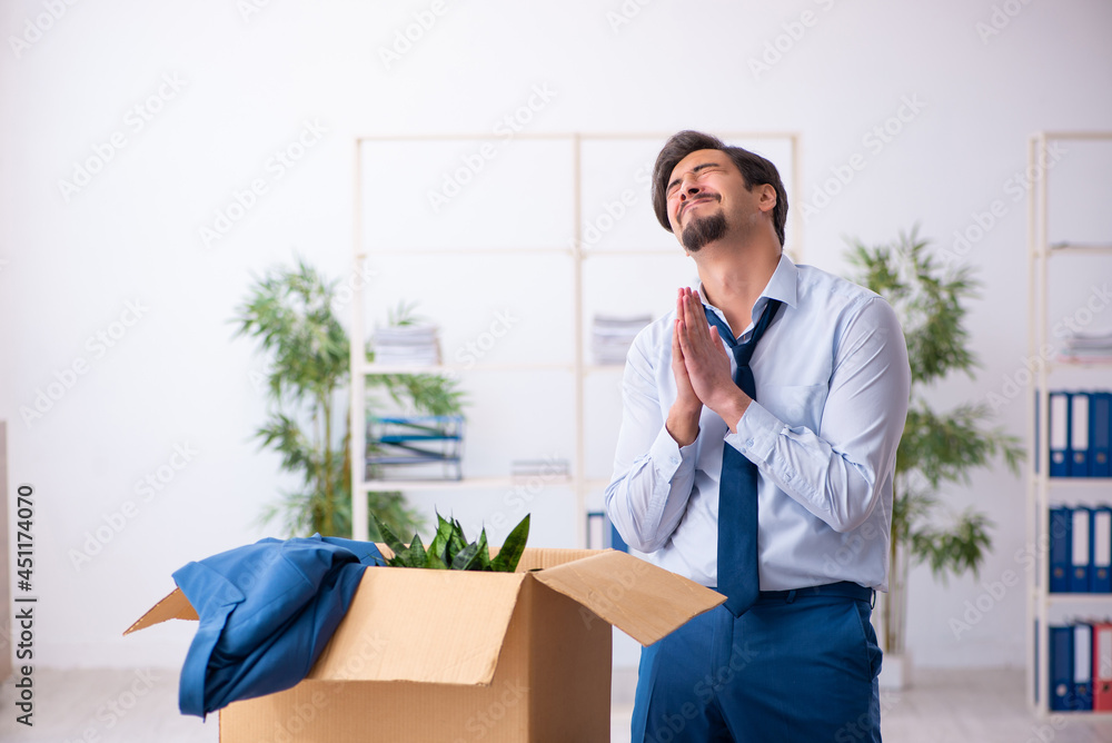 Young male employee in business relocation concept Young male employee in business relocation concept