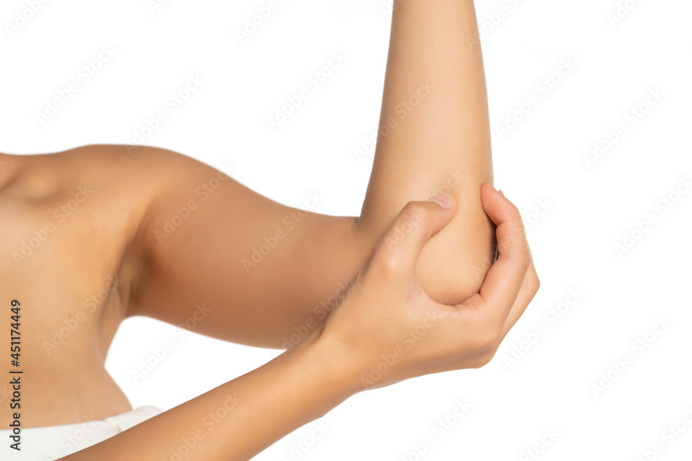 female massaging her aching elbow on a white background female massaging her aching elbow on a white background
