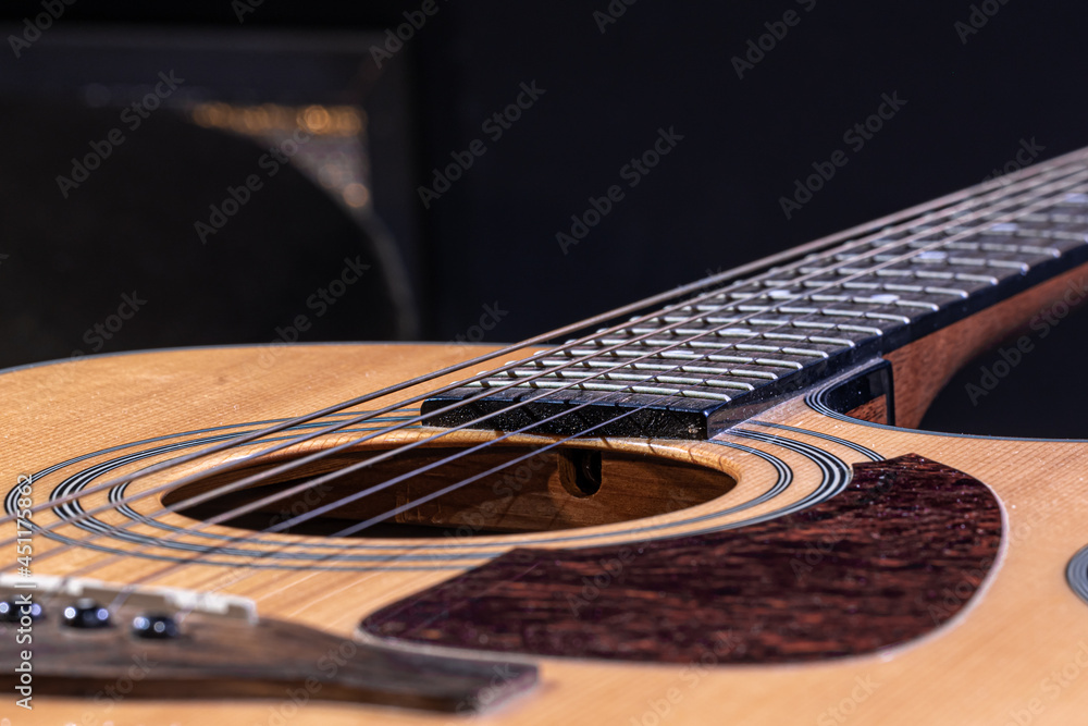 Fototapeta premium Close-up of a classical acoustic guitar on a black background.