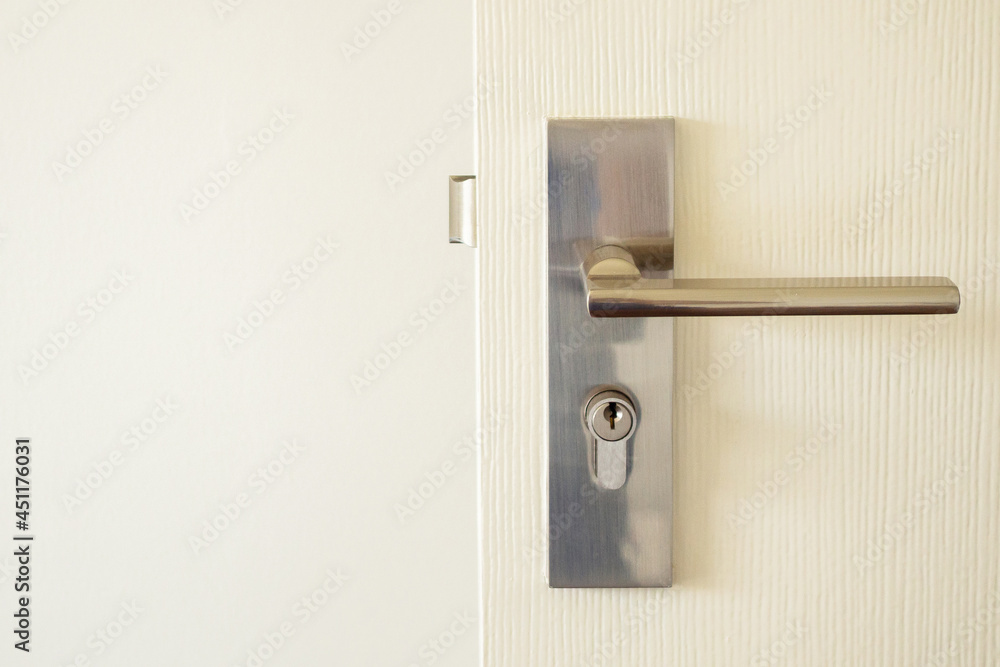 Modern door handle with keyhole on white door