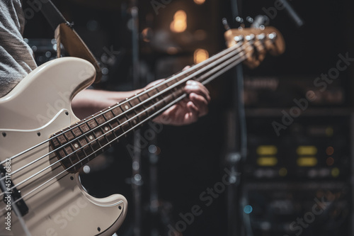 Close up of bass guitar on blurred dark background copy space.