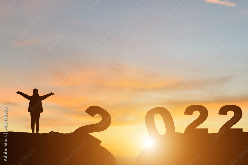 Young tourists stand with both hands on the top of the mountain in the morning with the view of the sunrise. She was delighted and happy for the coming new year soon. Young tourists stand with both hands on the top of the mountain in the morning with the view of the sunrise. She was delighted and happy for the coming new year soon.