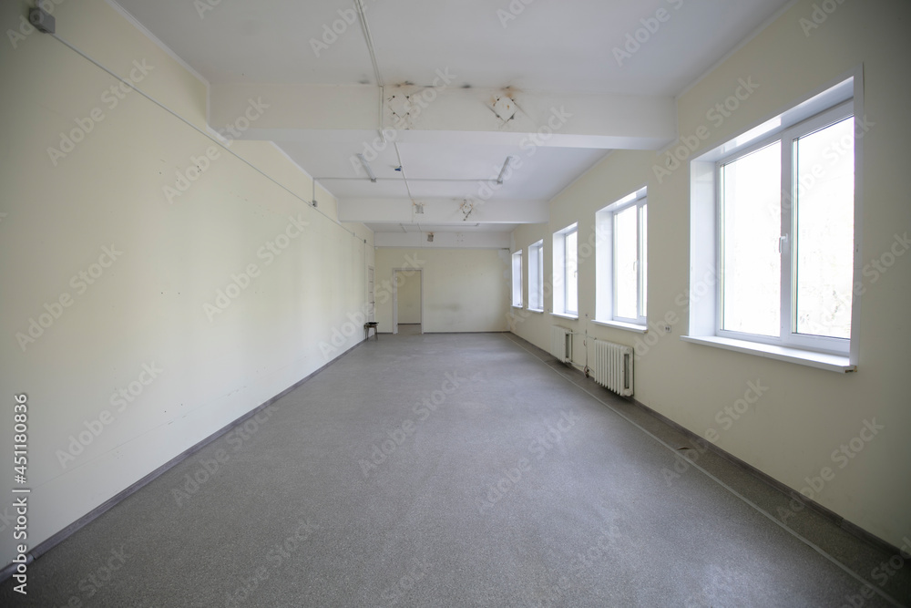 Obraz premium Empty white corridor with windows and gray floor.