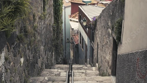 Small cosy steep street in old town city center of Porto in Portugal surrounded by walls and small old houses. photo