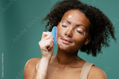 Beautiful young woman doing facial massage photo