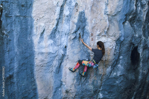 Fototapeta Naklejka Na Ścianę i Meble -  A strong girl climbs a rock, Rock climbing in Turkey.