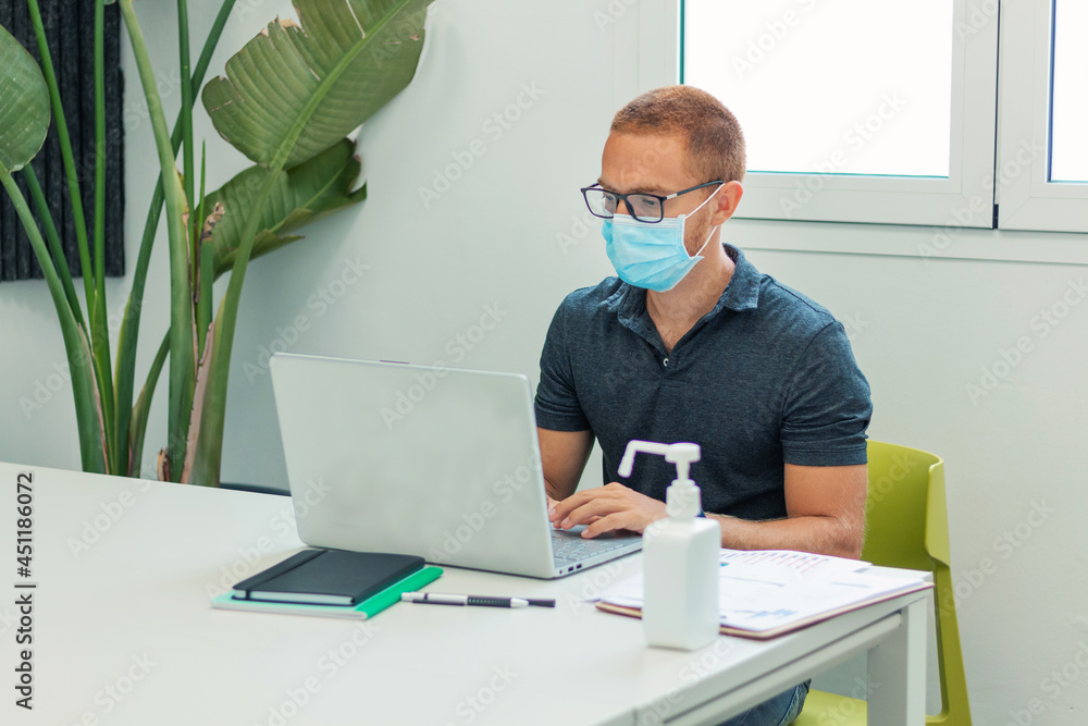 Businessman working in office with mask and hand sanitizer Businessman working in office with mask and hand sanitizer