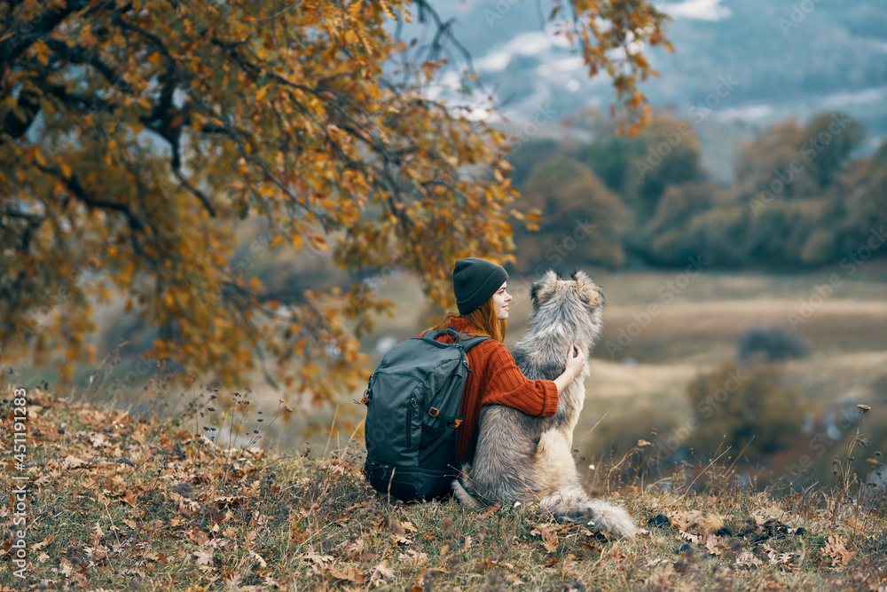 woman hiker with a backpack walks the dog in the mountains in nature woman hiker with a backpack walks the dog in the mountains in nature