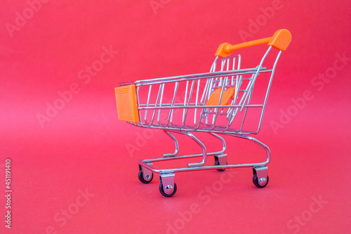 Mini shopping cart isolated on pink background with copy space.