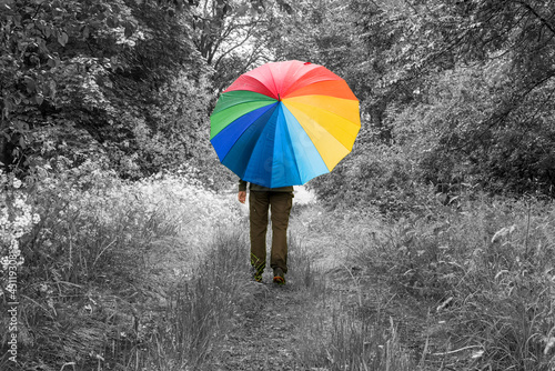 Person mit buntem Regenschirm in monochromer Landschaft
