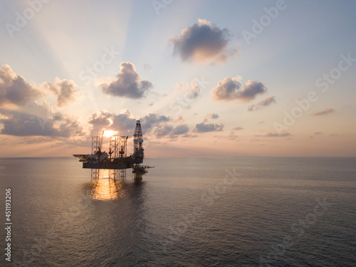 Offshore Jack Up Rig in The Middle of The Sea at Sunset Time for Petroluem Exploration and Production photo