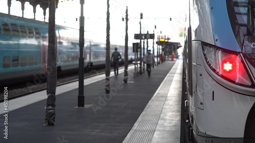 Train Parked At Main Train Station In Paris, France With People Wearing Mask Walking On The Platform Amidst Covid Pandemic. static
