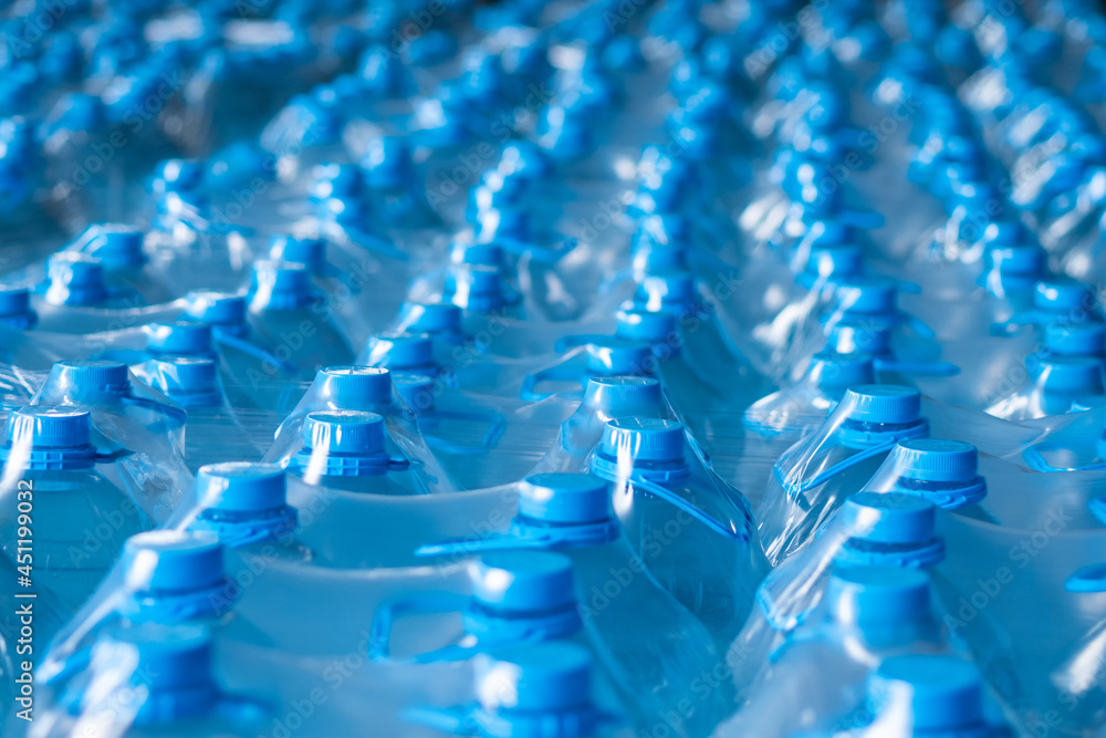 Blue plastic bottles of 5 liters packed in the finished product warehouse Blue plastic bottles of 5 liters packed in the finished product warehouse