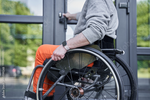 Physically challenged girl moving herself at the wheelchair and opening doors