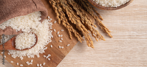 White rice in a bowl on wooden table background. photo