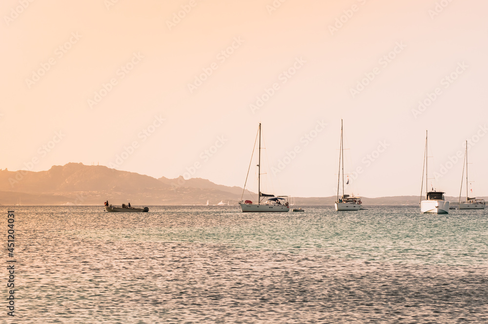 beautiful sea at sunset with sailboats and mountains in the background.Sardinia