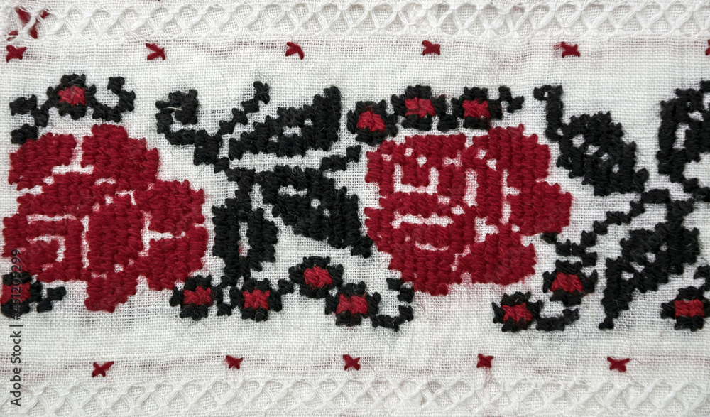 Traditional Ukrainian embroidery. Red and black roses on linen fabric