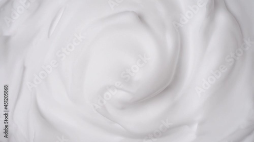 Foam swirl. Close view of thick shaving foam. Top view. Rotation photo